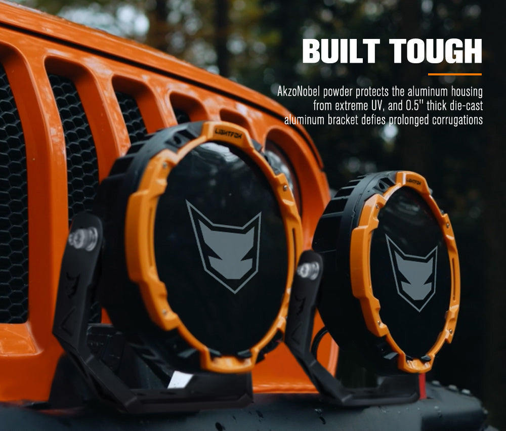 Two orange and black light covers on a vehicle grille with text about AkzoNobel powder protection.